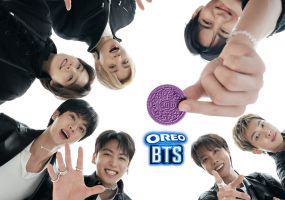 All seven BTS members gathered around a single purple OREO