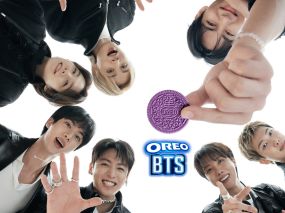 All seven BTS members gathered around a single purple OREO