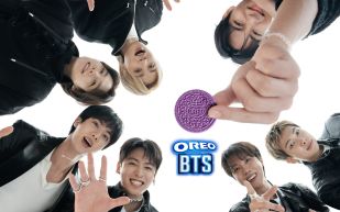 All seven BTS members gathered around a single purple OREO