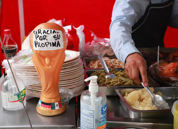 A World Cup trophy replica sits on a street food