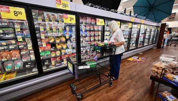 An elderly shopper checks food labels
