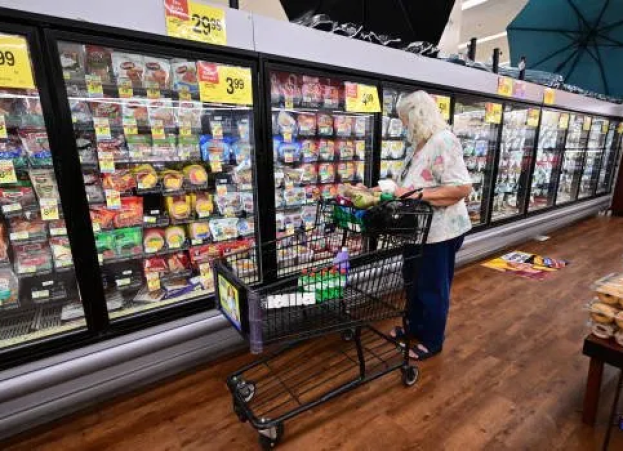 An elderly shopper checks food labels