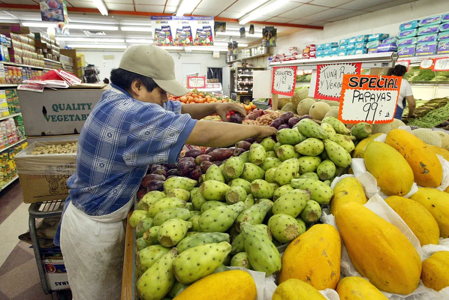 A worker arranges produce at a Latino grocery market