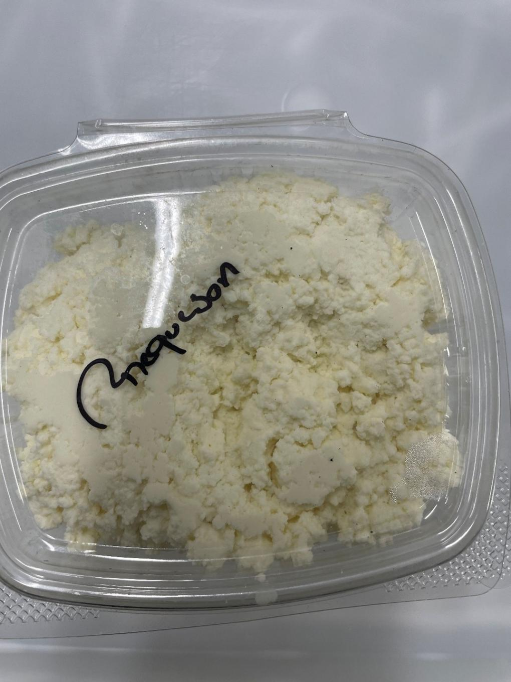 A clear plastic deli container of Clover Hill Dairy requeson 